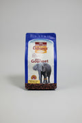 A bag of Gibson's Coffee Kenya Gourmet medium grind dark roast coffee, featuring a blue and white package with an elephant graphic, set against a dark fabric background.