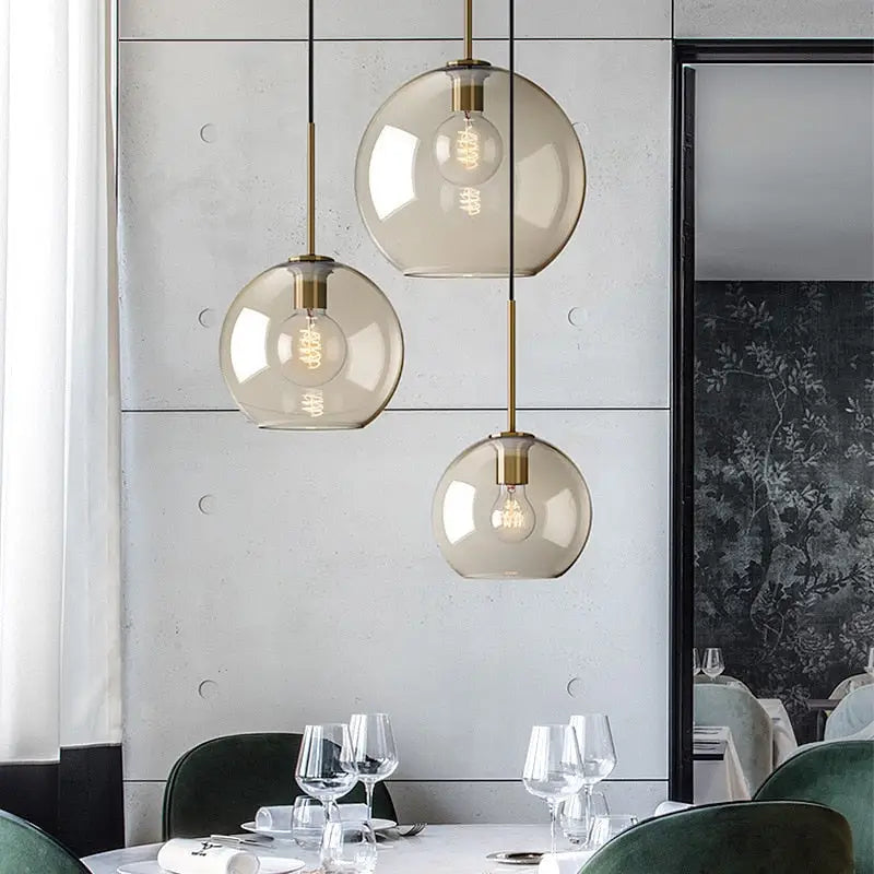 Modern smoked glass pendant lights with brass accents for kitchen island