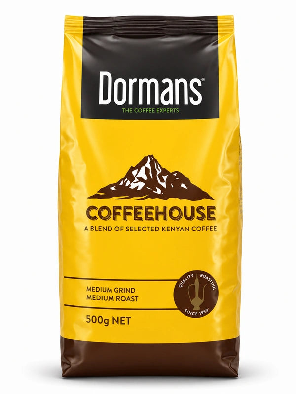 Dormans Coffeehouse Kenyan coffee 500g pouch shown in a clean, close-up front view, featuring the yellow and brown Coffeehouse packaging, Dormans Coffee Experts branding, mountain artwork, A Blend of Selected Kenyan Coffee labeling, medium grind, medium roast, quality roasting since 1950 emblem and clearly visible 500g net weight, presented as a realistic three-dimensional product image with smooth packaging, natural highlights, dimensional depth, crisp edges, soft shadow and a clean white Shopify WSS