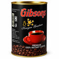 Gibsons Premium 100% Instant Coffee 250g tin featuring glossy black packaging, bold red Gibsons branding, gold five-star Kenyan Greatness design, red coffee cup and saucer, roasted coffee beans, gold metallic rims, KEBS mark, barcode, storage information, and Gibson Coffee Ltd. packaging details, displayed upright against a clean white studio background for Shopify product photography and Google Images. 