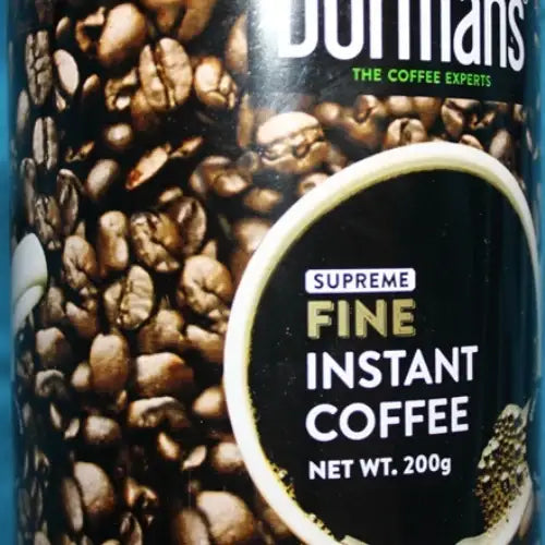 Dormans Fine Instant Coffee 200g in a cylindrical metal coffee tin, featuring the Dormans The Coffee Experts logo, roasted coffee bean packaging design, Fine Instant Coffee label, white coffee cup illustration, 200g net weight, quality and roasting badge, metallic silver tin edges, and gold lower label against a clean white studio background for World Safari Shops.